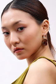 Model wearing Min & Lith Amber Fragment Drop Earrings, showcasing clear rectangular studs and richly textured amber-brown drops.