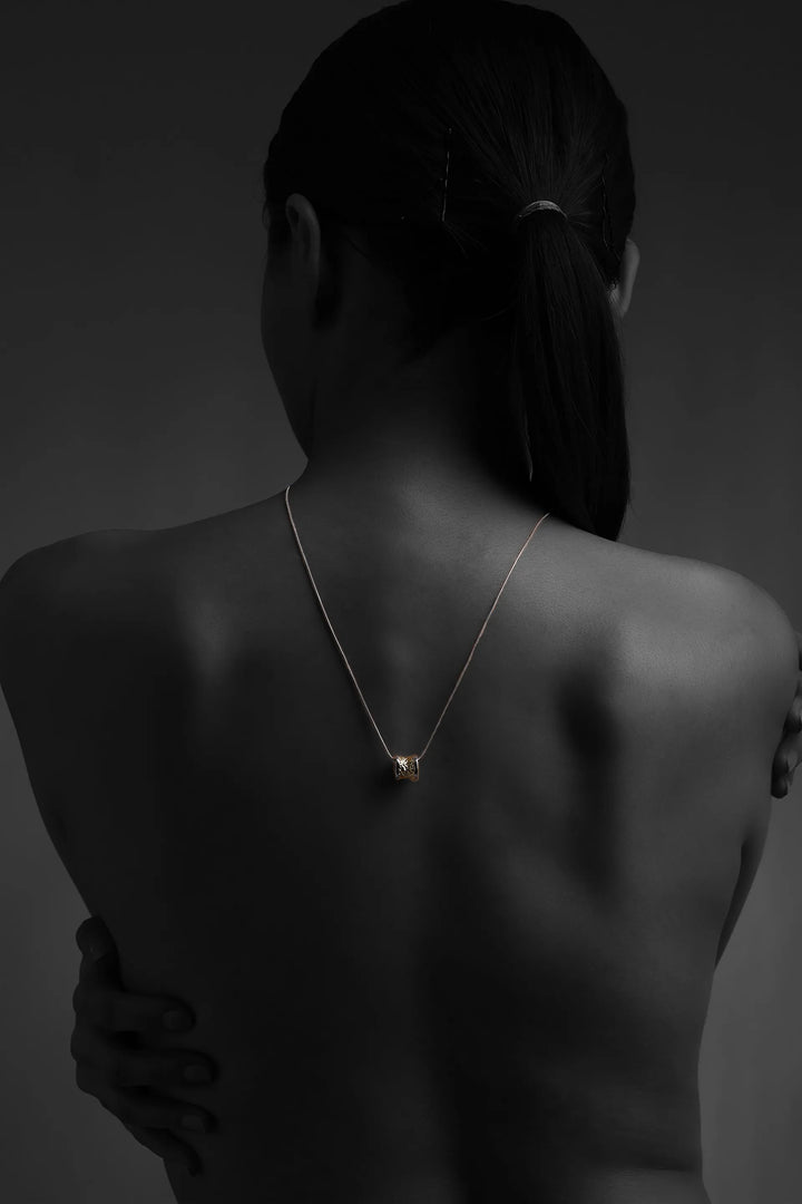 Core Form pendant necklace with textured gold core and minimal silver chain