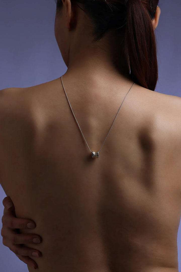 Core Form pendant necklace with textured gold core and minimal silver chain
