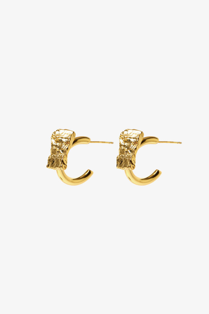 crust form hoop earrings with textured raw surface and gold hoop design