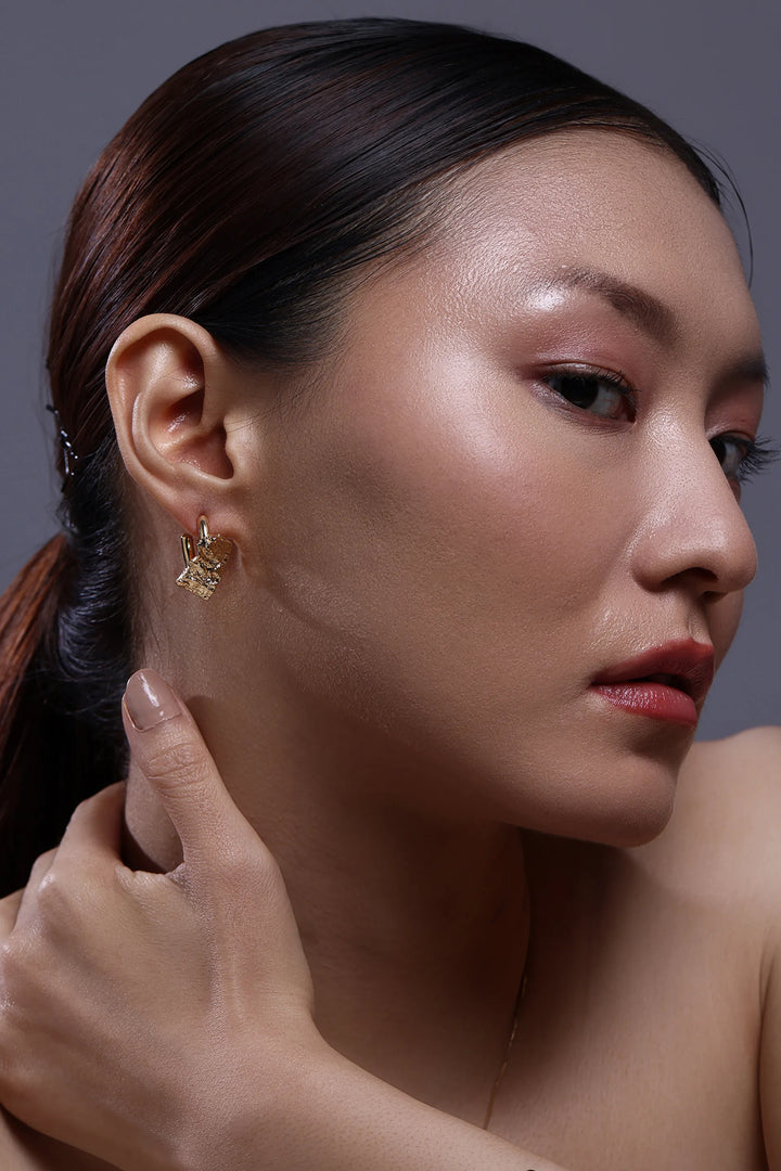 crust form hoop earrings with textured raw surface and gold hoop design