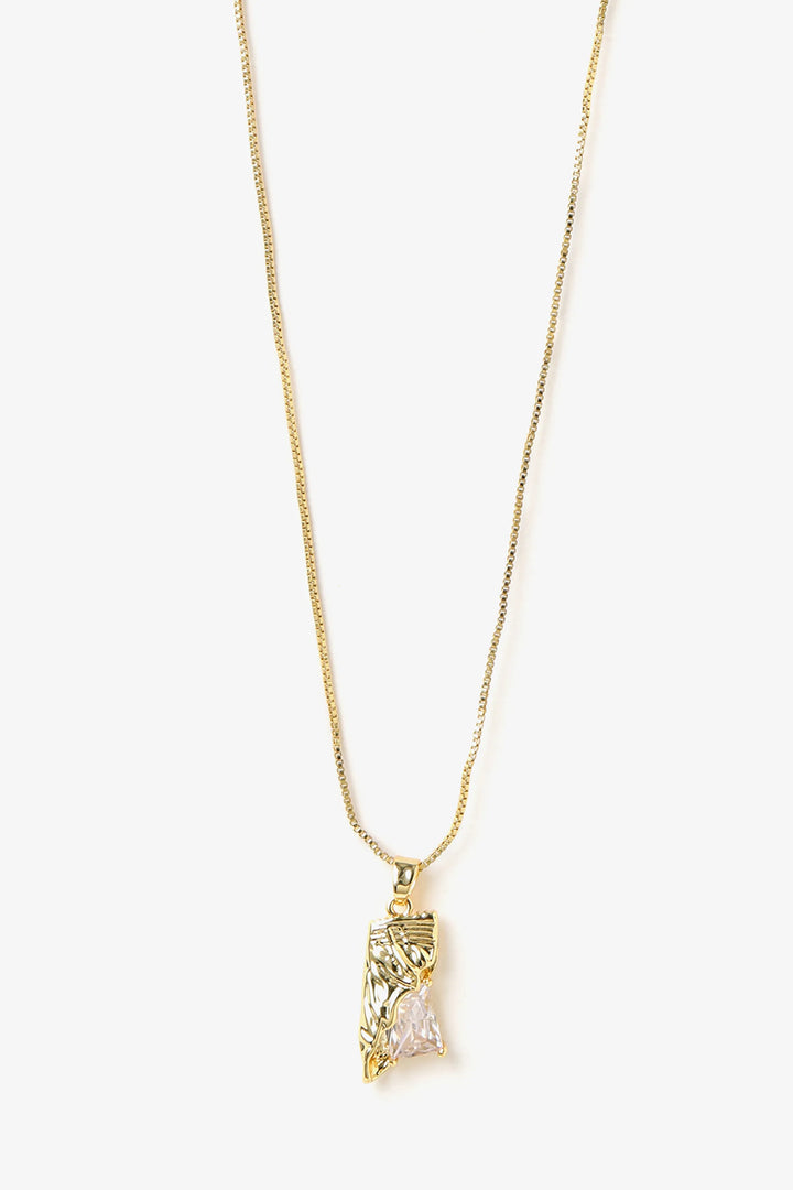 Close-up of sculpted pendant with raw crystal detail and textured metal surface