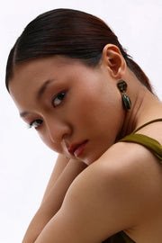 Model wearing Min & Lith Patina Drop Earrings, showcasing the turquoise-green textured drops and polished gold-toned oval tops.