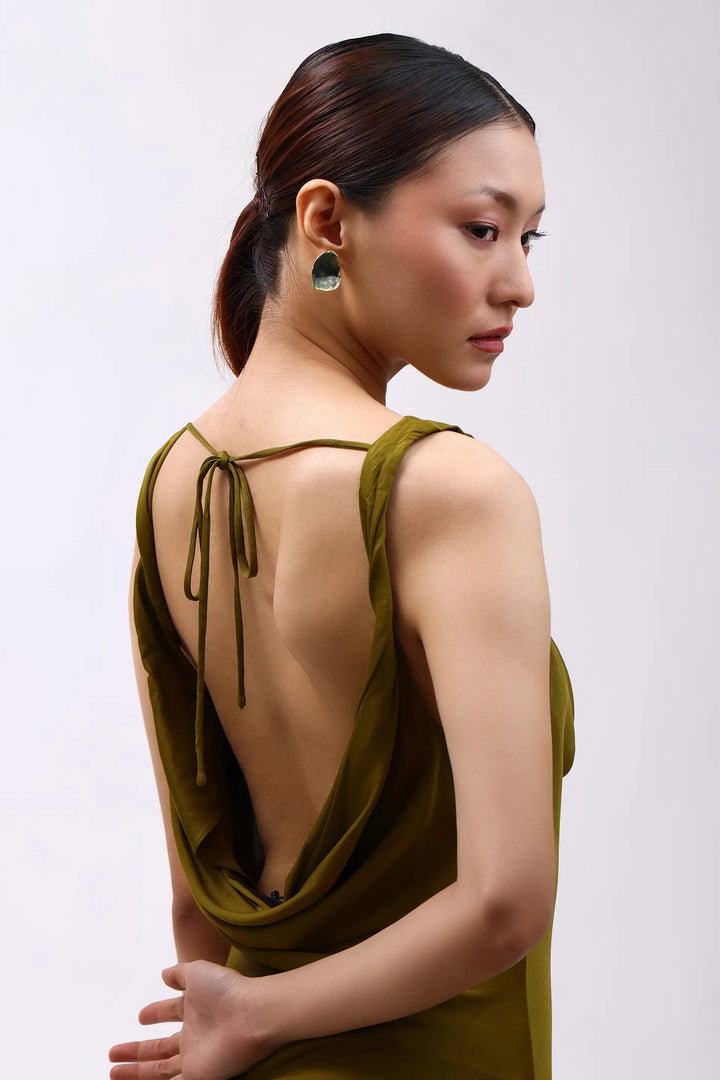Model wearing Min & Lith Verdant Stud Earrings, showcasing their deep olive-green colour, organic shape and gold-toned edging.
