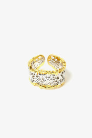 Close-up of textured sculptural ring showing woven surface detail and open band design