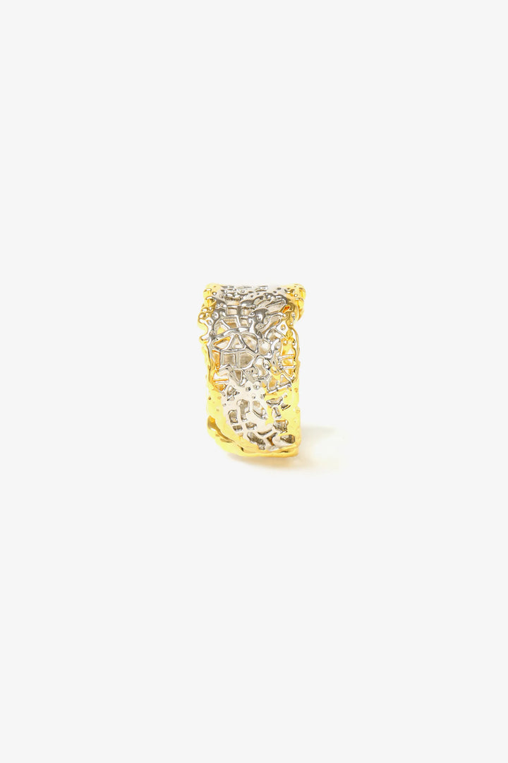 Close-up of textured sculptural ring showing woven surface detail and open band design