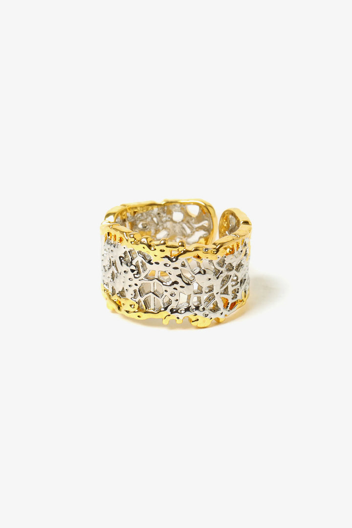 Close-up of textured sculptural ring showing woven surface detail and open band design